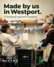 A man and a woman wearing white lab coats and blue gloves work together in a laboratory setting, with shelves of supplies in the background. Large text at the top reads 'Made by us in Westport.